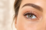 Close-up of a woman's eye with naturally lifted, curled eyelashes and soft, natural makeup.
